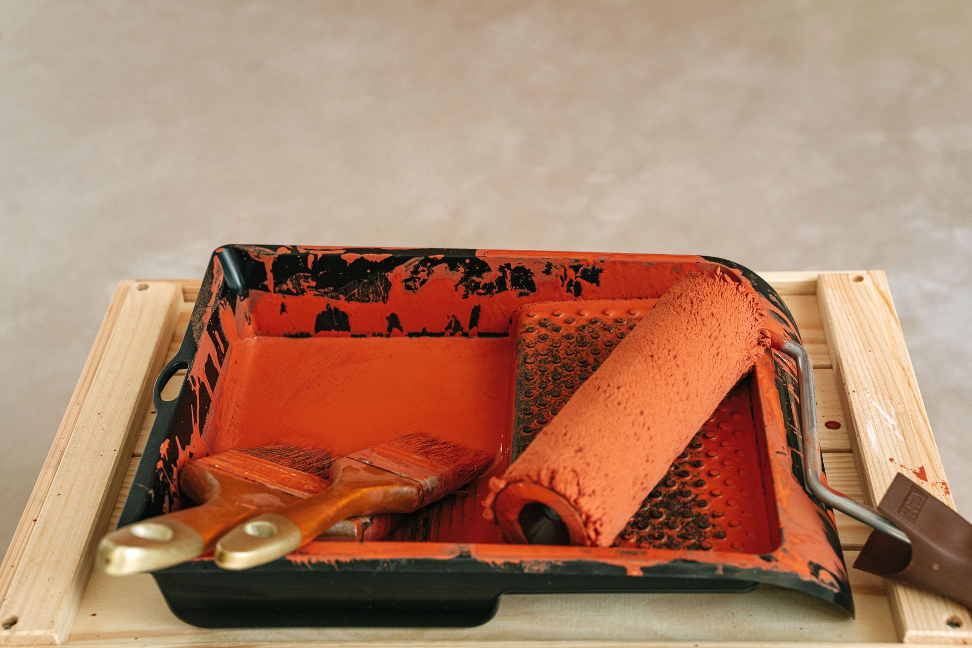 Paint roller and brushes in tray for home renovation and DIY projects.